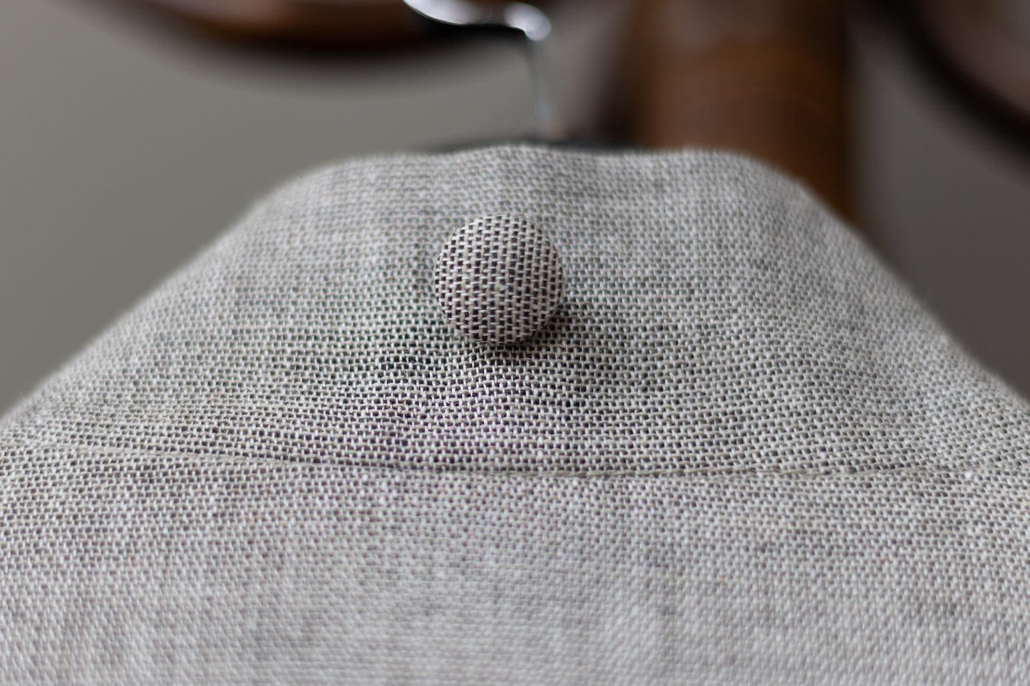 Rear view of the coat on hanger – shows silhouette and back button detail