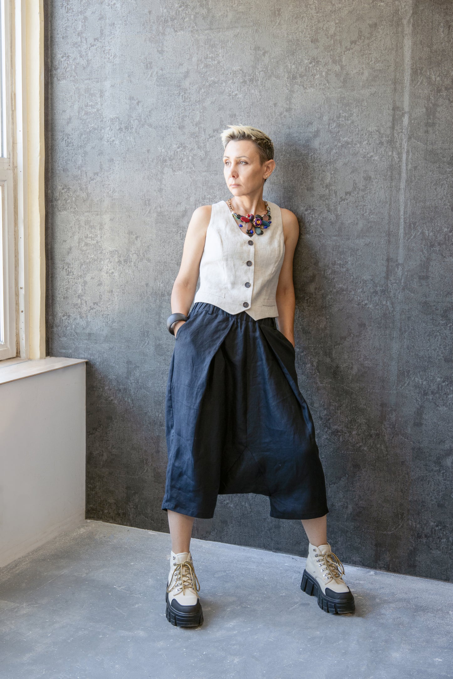 Side view of woman in asymmetrical pleated linen pants