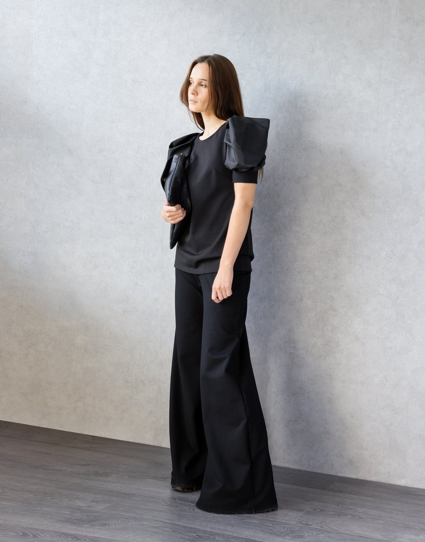 Black Puff Sleeve Blouse in fron of wall