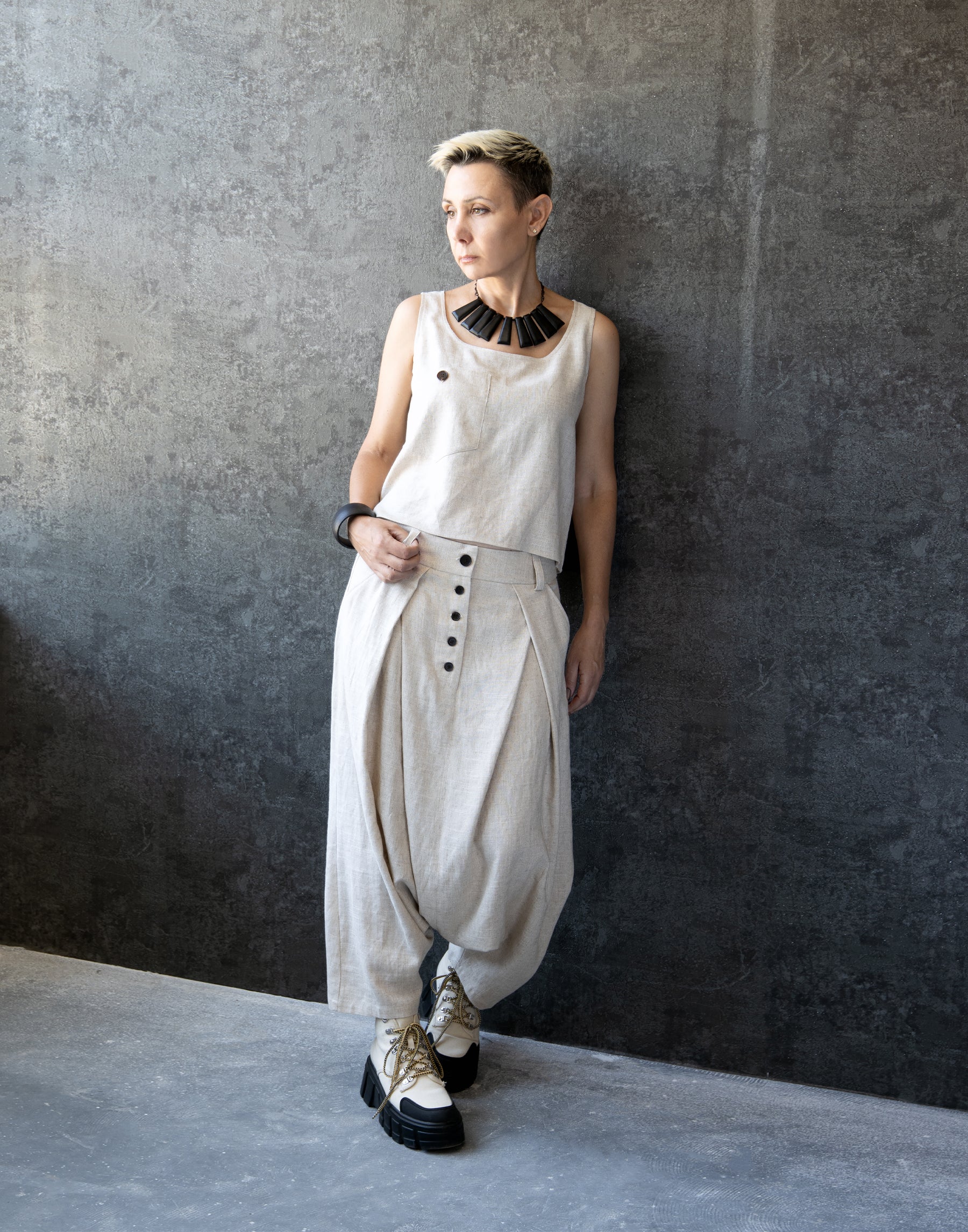Woman in Natural Linen Drop Crotch Pleated Trousers